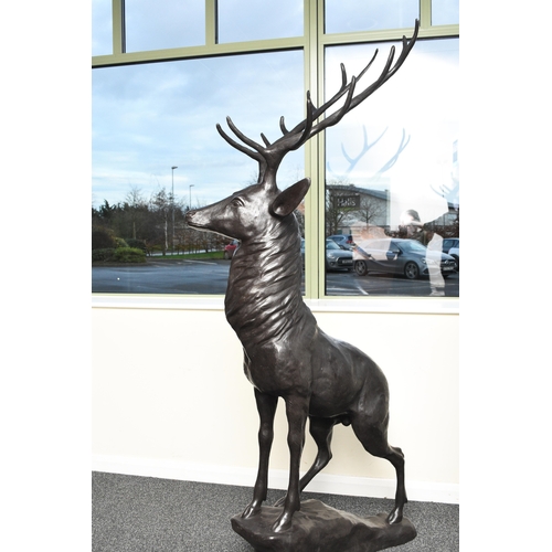 222 - A bronze garden statue of a stag Modern, modelled standing four square on a rocky outcrop. 204cm hig... 