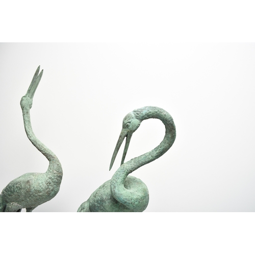 223 - A pair of bronze garden statues of crane birds, 20th century Both modelled standing, one with head r... 