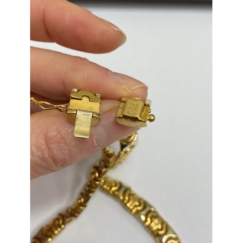 25 - A yellow and white metal decorative link collarette necklace, with integral clasp with attached safe... 