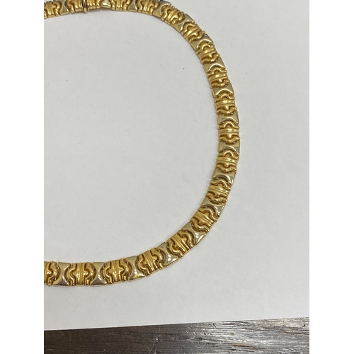 25 - A yellow and white metal decorative link collarette necklace, with integral clasp with attached safe... 