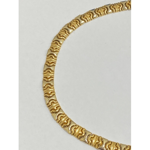 25 - A yellow and white metal decorative link collarette necklace, with integral clasp with attached safe... 