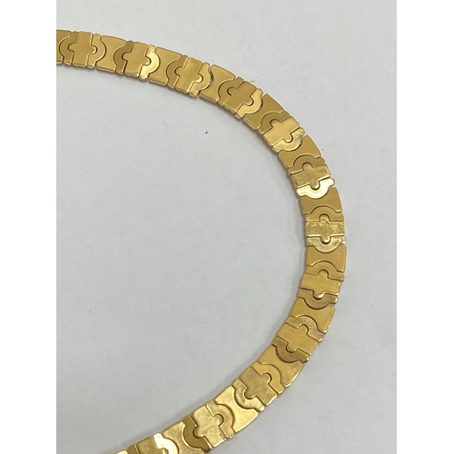 25 - A yellow and white metal decorative link collarette necklace, with integral clasp with attached safe... 