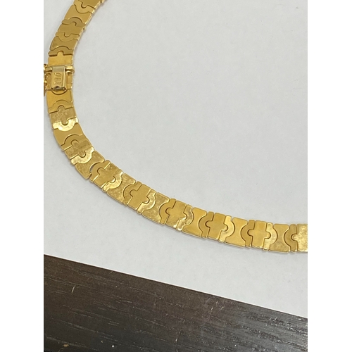 25 - A yellow and white metal decorative link collarette necklace, with integral clasp with attached safe... 