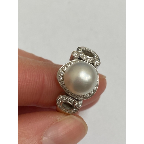 26 - A De Beers 18ct white gold cultured pearl and diamond ring, designed as a central single cultured pe... 