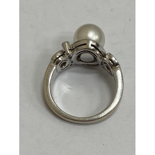 26 - A De Beers 18ct white gold cultured pearl and diamond ring, designed as a central single cultured pe... 