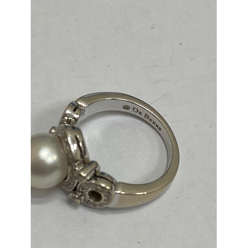 26 - A De Beers 18ct white gold cultured pearl and diamond ring, designed as a central single cultured pe... 