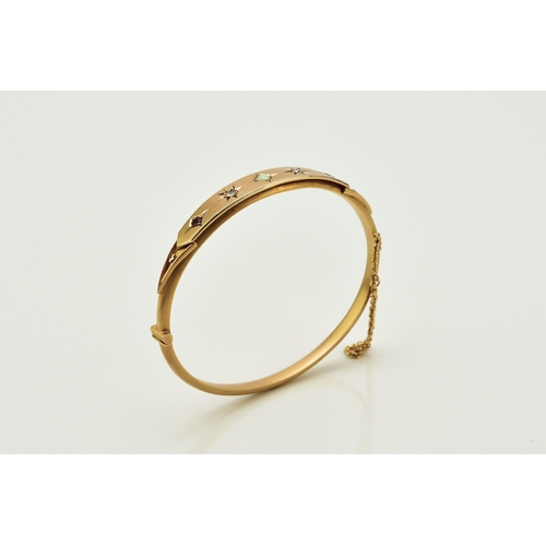 28 - An opal, diamond and red paste bangle, designed as a central round cabochon opal flanked to each sid... 