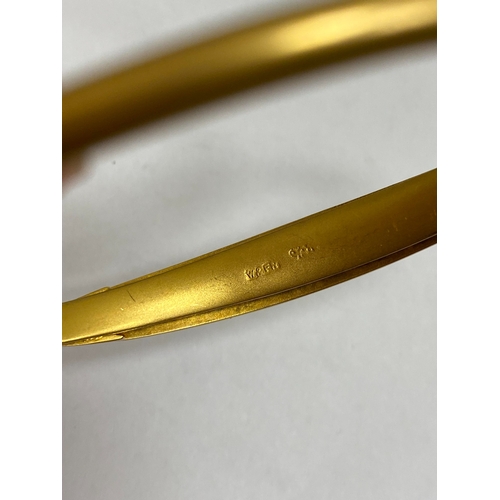 28 - An opal, diamond and red paste bangle, designed as a central round cabochon opal flanked to each sid... 