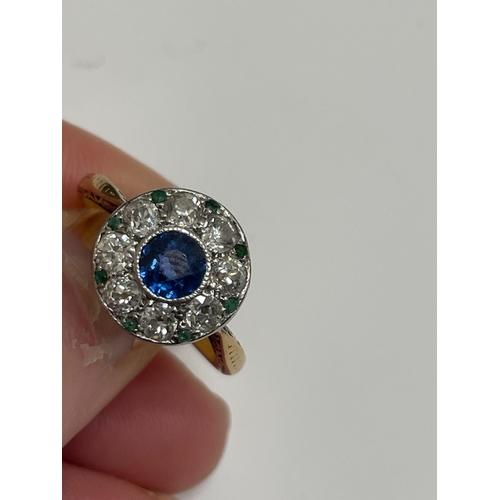 29 - An early-mid 20th century sapphire, diamond and emerald cluster ring, designed as a central round mi... 