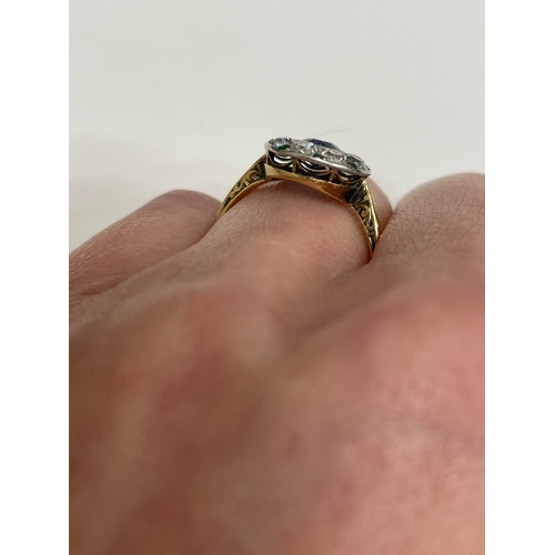 29 - An early-mid 20th century sapphire, diamond and emerald cluster ring, designed as a central round mi... 