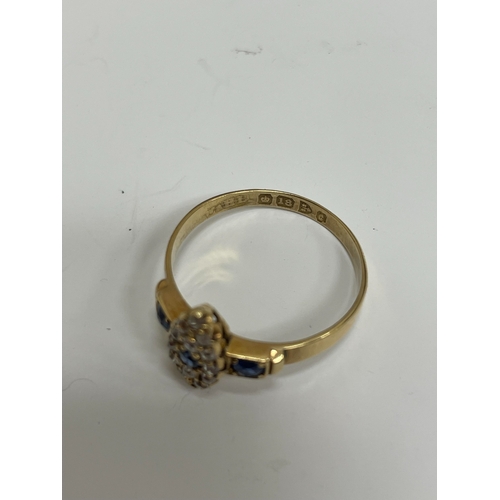 30 - An 18ct gold Edwardian sapphire and diamond ring, designed as a central round cut sapphire claw set ... 