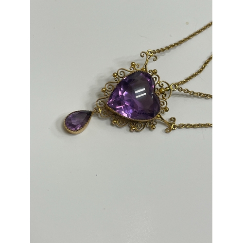 31 - An amethyst pendant necklace, designed as a heart shaped faceted amethyst within a cannetille scroll... 