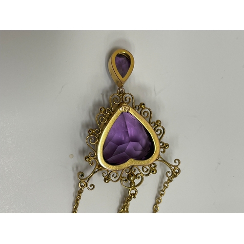 31 - An amethyst pendant necklace, designed as a heart shaped faceted amethyst within a cannetille scroll... 