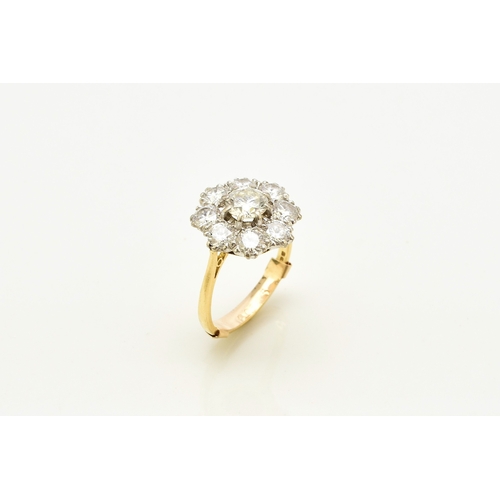 32 - An 18ct gold diamond floral cluster ring, designed as a central brilliant cut diamond claw set in wh... 