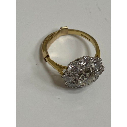 32 - An 18ct gold diamond floral cluster ring, designed as a central brilliant cut diamond claw set in wh... 
