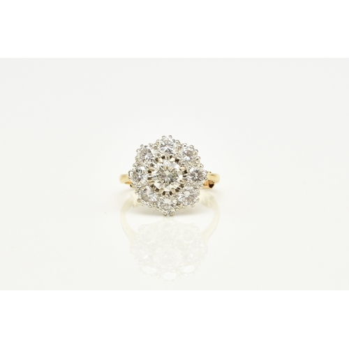 32 - An 18ct gold diamond floral cluster ring, designed as a central brilliant cut diamond claw set in wh... 