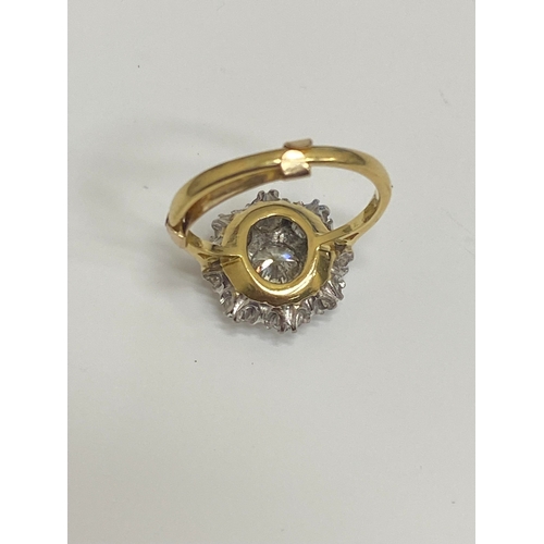 32 - An 18ct gold diamond floral cluster ring, designed as a central brilliant cut diamond claw set in wh... 