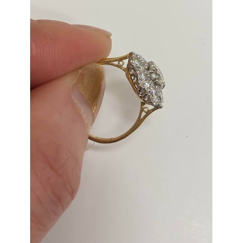 32 - An 18ct gold diamond floral cluster ring, designed as a central brilliant cut diamond claw set in wh... 