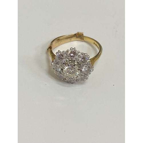 32 - An 18ct gold diamond floral cluster ring, designed as a central brilliant cut diamond claw set in wh... 