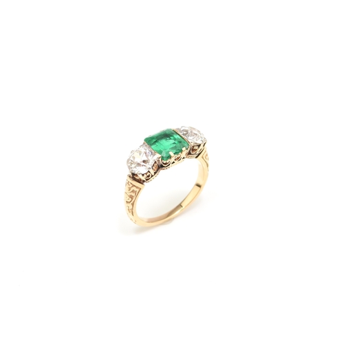 37 - A late 19th / early 20th century three stone emerald and diamond ring, designed as a central square ... 