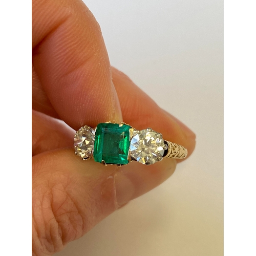 37 - A late 19th / early 20th century three stone emerald and diamond ring, designed as a central square ... 