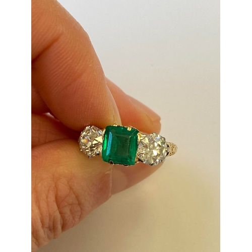 37 - A late 19th / early 20th century three stone emerald and diamond ring, designed as a central square ... 