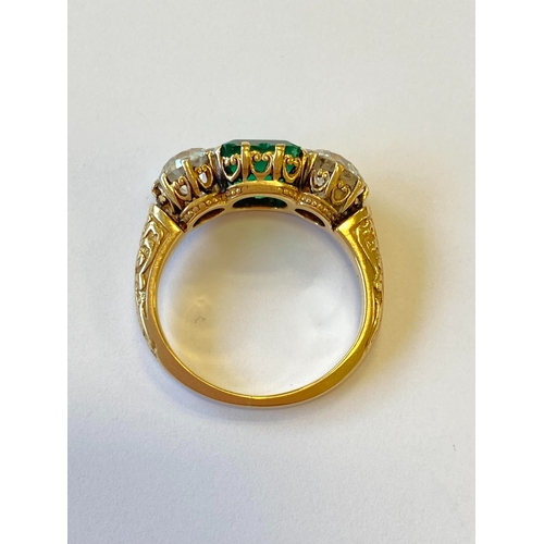 37 - A late 19th / early 20th century three stone emerald and diamond ring, designed as a central square ... 