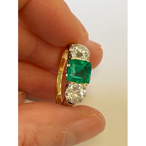 37 - A late 19th / early 20th century three stone emerald and diamond ring, designed as a central square ... 