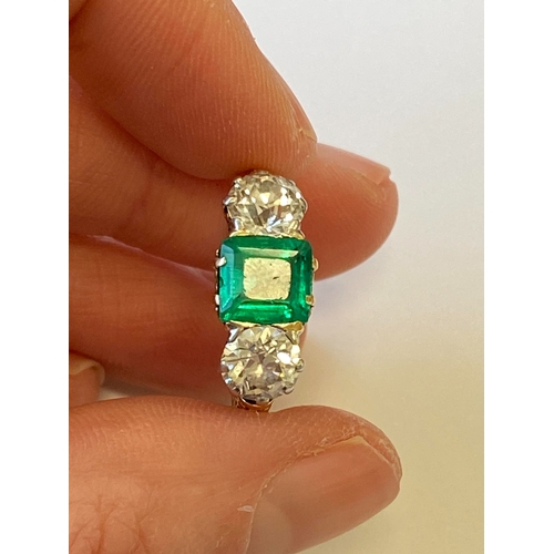 37 - A late 19th / early 20th century three stone emerald and diamond ring, designed as a central square ... 
