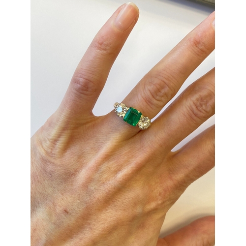 37 - A late 19th / early 20th century three stone emerald and diamond ring, designed as a central square ... 