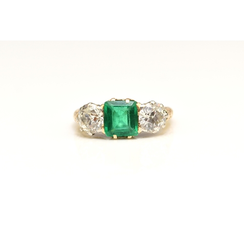 37 - A late 19th / early 20th century three stone emerald and diamond ring, designed as a central square ... 