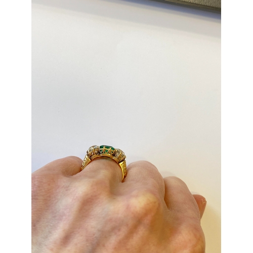 37 - A late 19th / early 20th century three stone emerald and diamond ring, designed as a central square ... 
