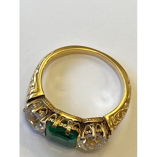37 - A late 19th / early 20th century three stone emerald and diamond ring, designed as a central square ... 