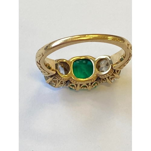 37 - A late 19th / early 20th century three stone emerald and diamond ring, designed as a central square ... 