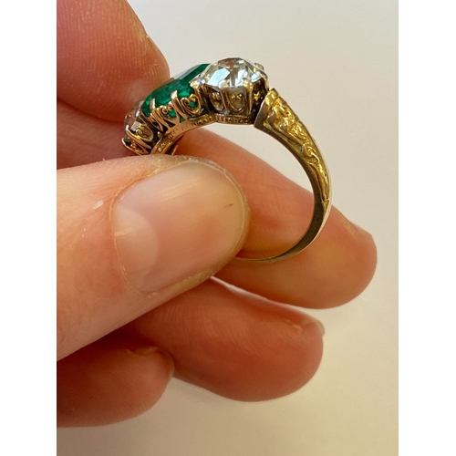 37 - A late 19th / early 20th century three stone emerald and diamond ring, designed as a central square ... 
