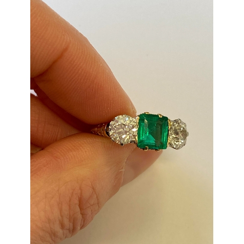 37 - A late 19th / early 20th century three stone emerald and diamond ring, designed as a central square ... 