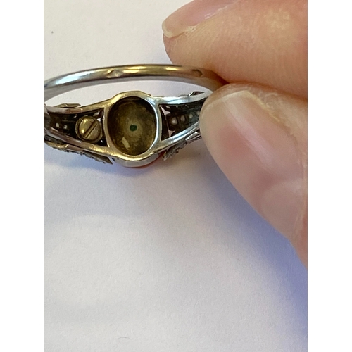 38 - A French Art Deco coral and diamond ring, designed as a single oval cabochon coral mounted within gr... 