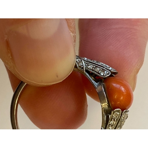38 - A French Art Deco coral and diamond ring, designed as a single oval cabochon coral mounted within gr... 