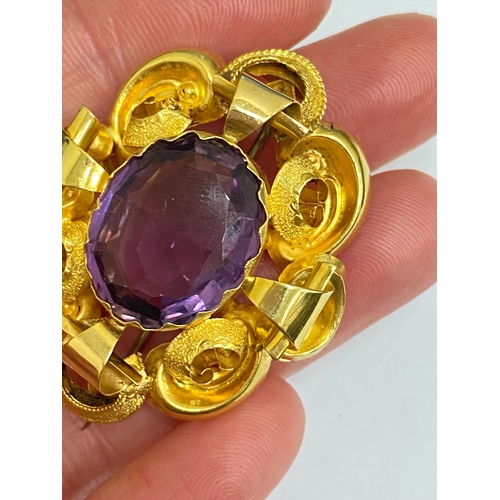 39 - A Victorian amethyst brooch, designed as a central oval mixed cut amethyst claw set within a yellow ... 