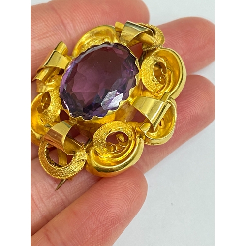 39 - A Victorian amethyst brooch, designed as a central oval mixed cut amethyst claw set within a yellow ... 