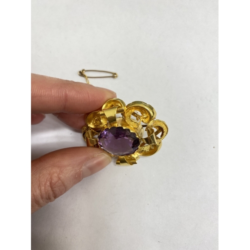 39 - A Victorian amethyst brooch, designed as a central oval mixed cut amethyst claw set within a yellow ... 