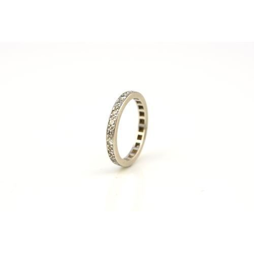 41 - A diamond set eternity ring, the round faceted diamonds claw set in white metal to white metal shank... 
