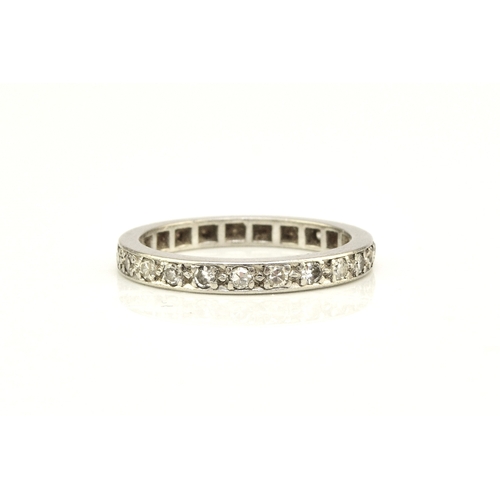 41 - A diamond set eternity ring, the round faceted diamonds claw set in white metal to white metal shank... 