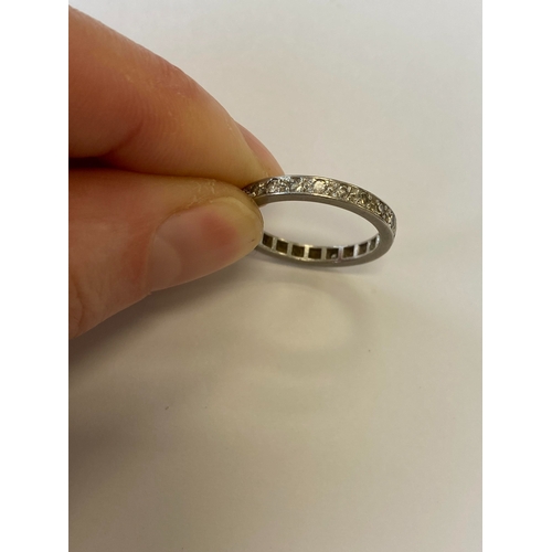 41 - A diamond set eternity ring, the round faceted diamonds claw set in white metal to white metal shank... 