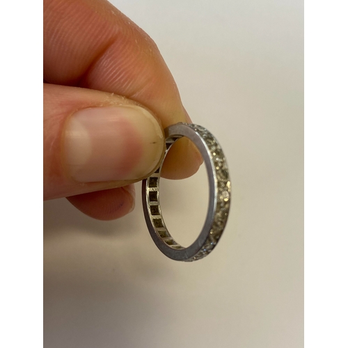 41 - A diamond set eternity ring, the round faceted diamonds claw set in white metal to white metal shank... 