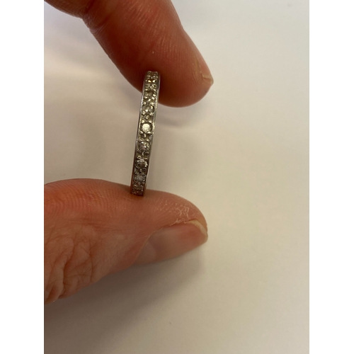 41 - A diamond set eternity ring, the round faceted diamonds claw set in white metal to white metal shank... 