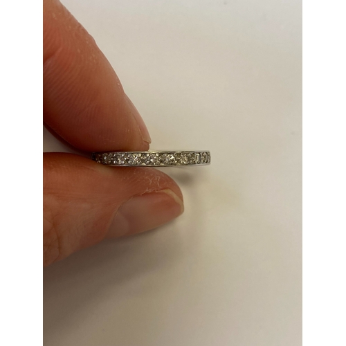 41 - A diamond set eternity ring, the round faceted diamonds claw set in white metal to white metal shank... 