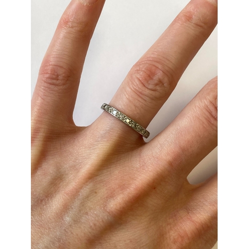 41 - A diamond set eternity ring, the round faceted diamonds claw set in white metal to white metal shank... 