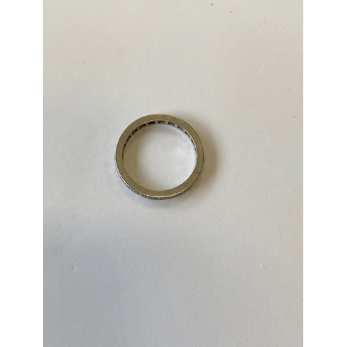 41 - A diamond set eternity ring, the round faceted diamonds claw set in white metal to white metal shank... 
