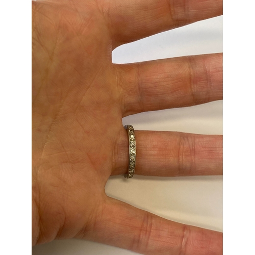 41 - A diamond set eternity ring, the round faceted diamonds claw set in white metal to white metal shank... 